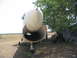 1981 Kawasaki Bayou - Front view of an abandoned aircraft fuselage resting on its landing gear in a rural outdoor setting.