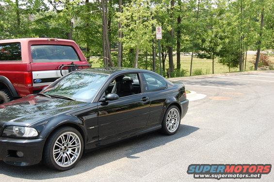 Black 2002 BMW M3 coupe parked next to a red Ford Bronco