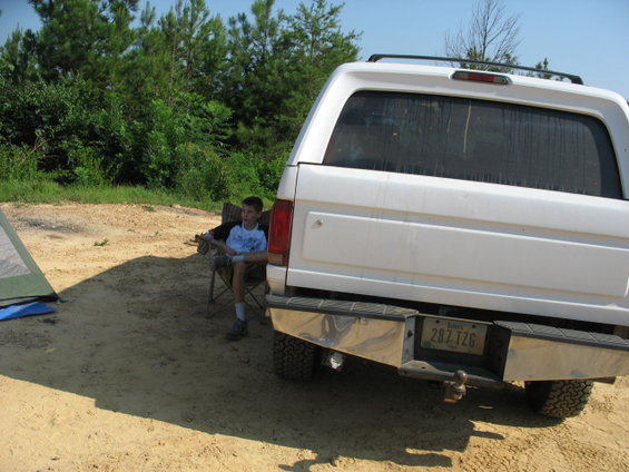Rear view of a white SUV with a chrome bumper and license plate 287 TZG