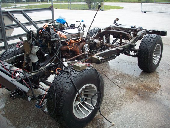 Vehicle frame with engine, transmission, and wheels. Body is missing