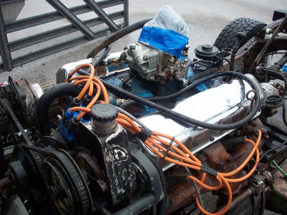 close-up of a vehicle engine with chrome valve covers and orange spark plug wires