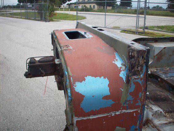 Jeep CJ-series firewall with peeling red and blue paint, brake booster attached