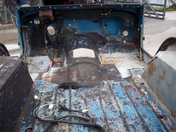 Blue 1978 Jeep CJ-5 tub interior, showing rusted floor and exposed wiring