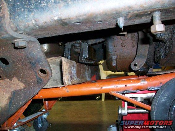 Underbody view with orange support beams and jack. Part number C-119 visible