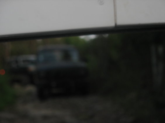 Dark colored truck seen through a window, blurry