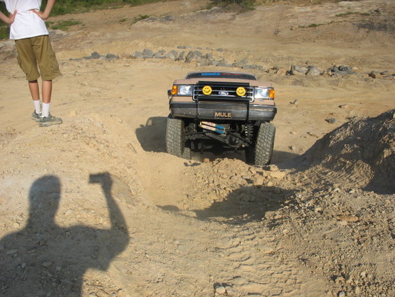 Tan off-road vehicle with smiley face headlights and "MULE" plate