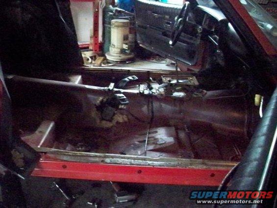 Interior of a 1974 Pontiac Firebird during restoration, showing stripped floor and dashboard