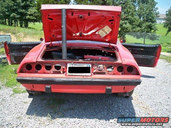 red car, trunk and doors open, missing taillights and bumper guards