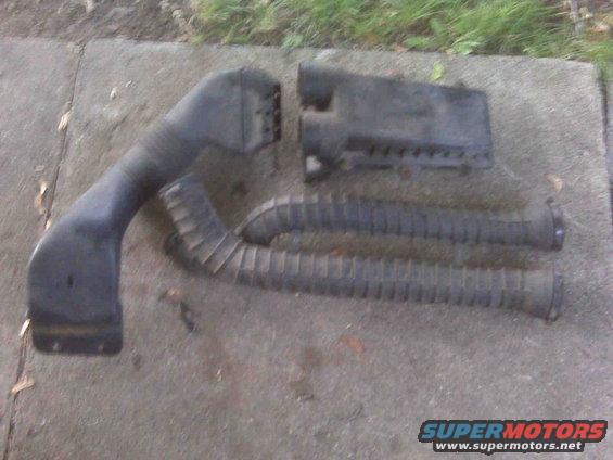 Black plastic air intake hose and filter box on concrete