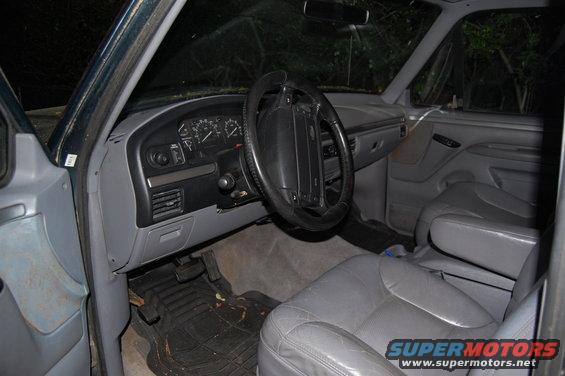 Gray leather interior of a 1992 Ford Bronco, showing dashboard, steering wheel, and seats