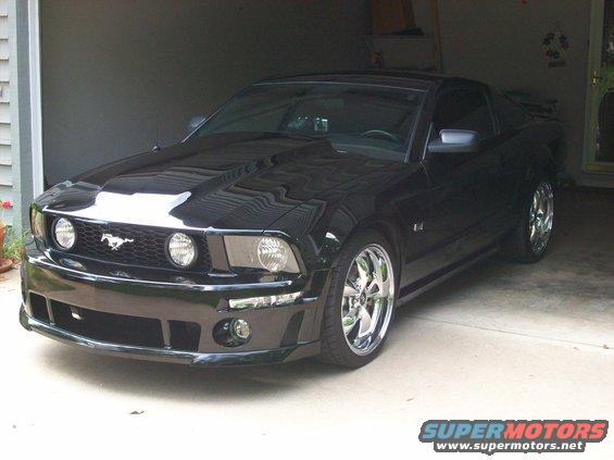Black 2007 Ford Mustang parked in a garage with chrome wheels