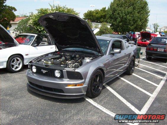 Gray 2007 Ford Mustang with hood open, parked at a car show