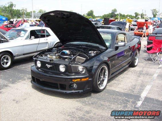 Black 2007 Ford Mustang with hood open, parked next to a silver Mustang