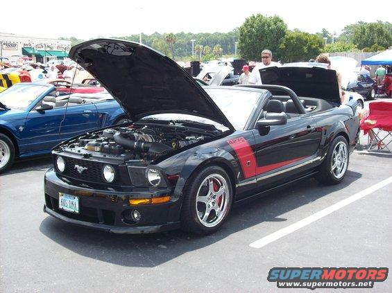 Black 2007 Ford Mustang convertible with hood open, red stripe on fender