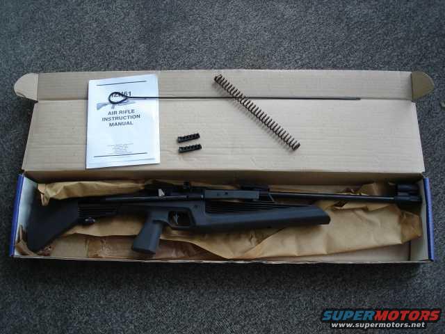 Air rifle and instruction manual in an open cardboard box