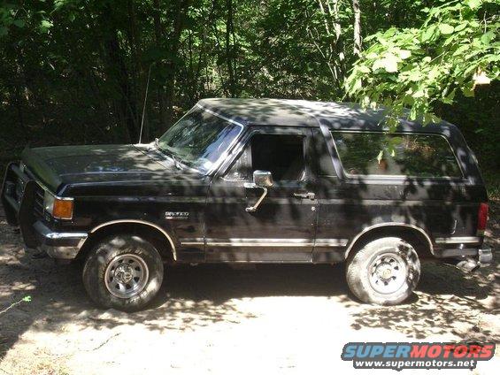 Side view of a black 1990 Ford Bronco with a brush guard