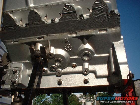 Engine block with spark plugs visible, some covered with black tape