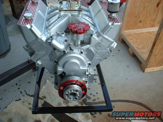 Silver V8 engine on a stand, with red distributor cap and air filter