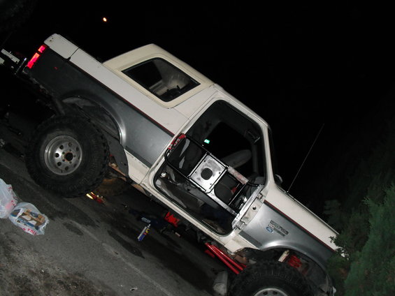 White and gray Ford Bronco with door open, lifted suspension, off-road tires