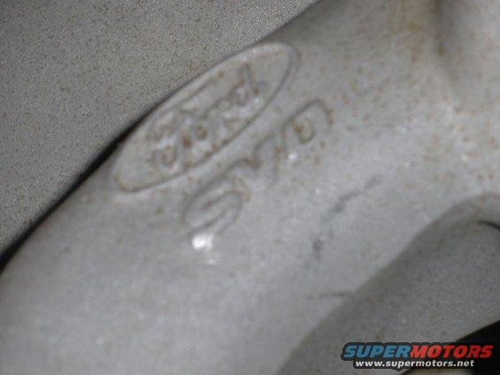 Close-up of a cast metal part showing the Ford logo and some casting numbers