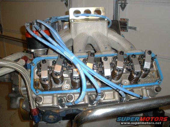 Close-up of V8 engine with blue spark plug wires and aluminum intake manifold