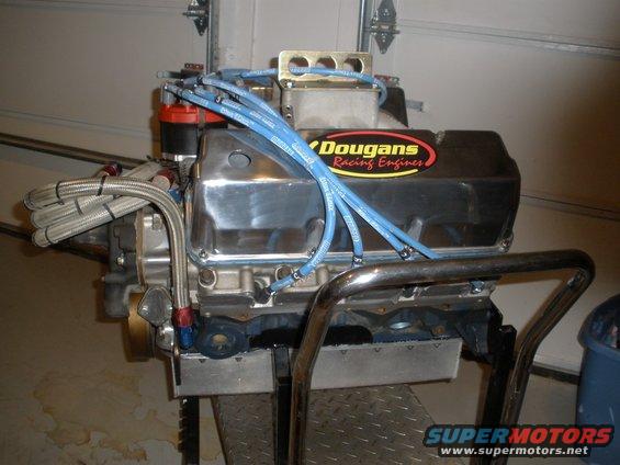 Chrome engine with blue spark plug wires and a "Dougan's Racing Engines" sticker