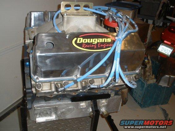 Chrome engine with blue spark plug wires and a "Dougan's Racing Engines" sticker