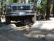 1984 Ford Bronco - A Ford Bronco navigates a rocky trail, its front grille and license plate clearly visible.