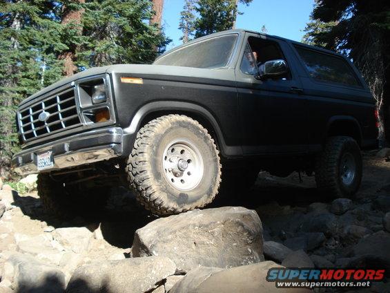 Ford Bronco with aftermarket wheels and tires navigating rocky terrain