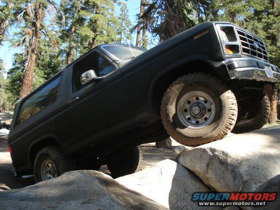 Ford Bronco climbing over rocks on a trail