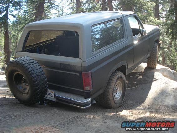 Ford Bronco on rocky terrain, spare tire mounted on rear door. License plate reads EW620