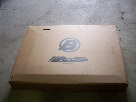 Cardboard box with Bestop logo and website address, lying flat on a concrete surface