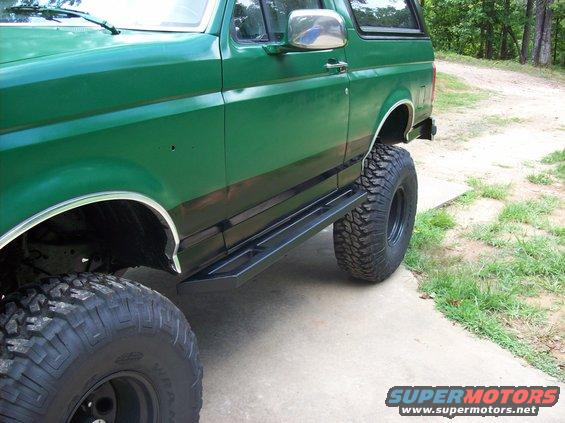Green 1992 Ford Bronco side view with large tires and aftermarket side steps