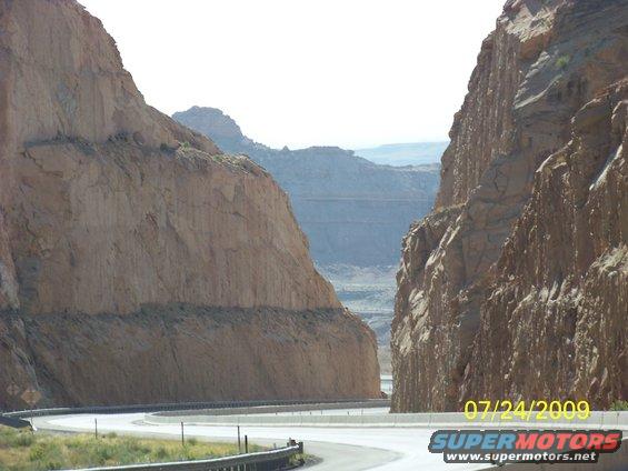 Road curves through a canyon with steep rock formations on either side