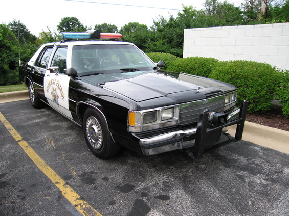 Black and white police car with "Highway Patrol" on the door and a light bar on top