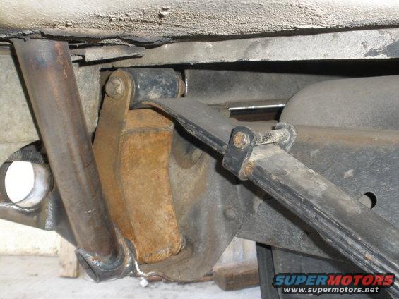 Close-up of leaf spring and shock mount on a vehicle's rear suspension