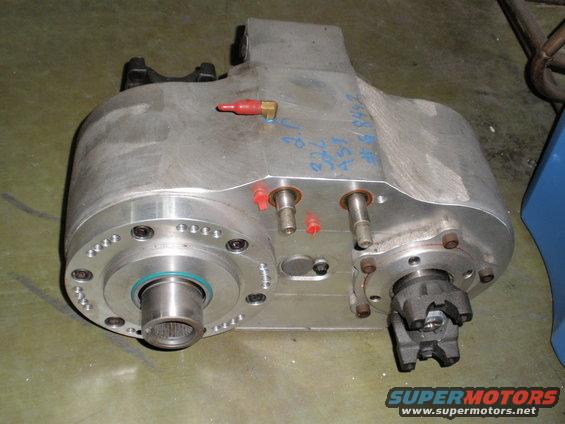 Aluminum transfer case with red caps on fittings and blue writing on top