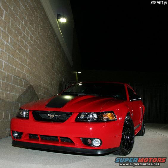 Red 2004 Ford Mustang front 3/4 view with black hood stripe