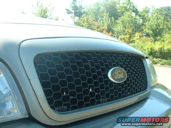 Close-up of a Ford Crown Victoria's honeycomb grille with the Ford oval badge