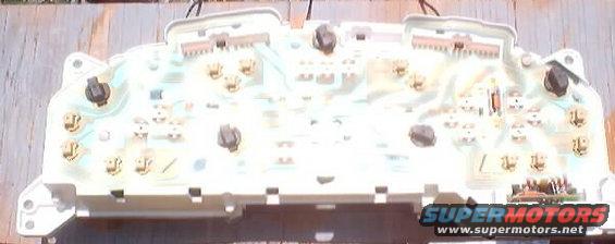 Back of an automotive instrument cluster circuit board with connectors and solder points