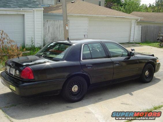 Black 2000 Ford Crown Victoria sedan, rear-left quarter view, parked on concrete driveway