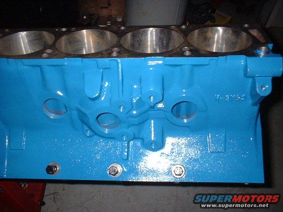Blue painted engine block with cylinder bores visible at the top