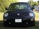 1999 Volkswagen Beetle - A black Volkswagen Beetle is shown from the front, parked outdoors on a grassy area.