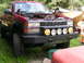1984 Chevrolet Blazer - This red pickup truck has an open hood and an aftermarket bumper with auxiliary lights.