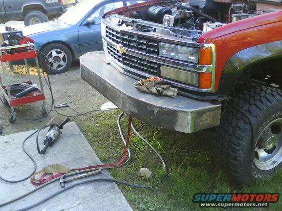 Red truck front with custom bumper, open hood, and 1988 grille