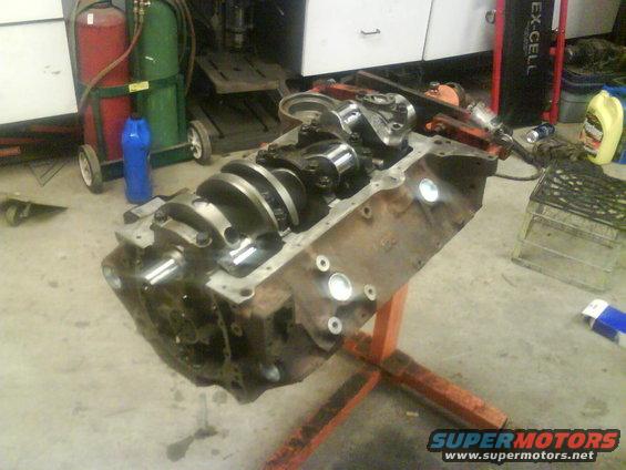 Engine block with crankshaft installed, on an orange engine stand