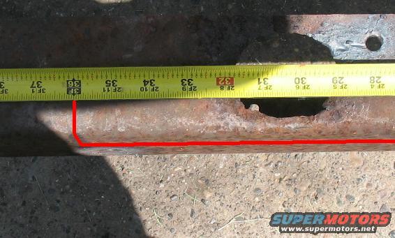 Rusted metal bar measured with a yellow tape measure showing approximately 3 feet