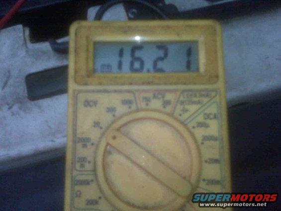 Yellow digital multimeter displaying 16.21, with various settings and ranges visible