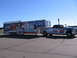 1998 GMC Sierra 1500 - Truck and trailer display National Guard and racing team sponsorship graphics under a clear sky.