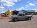1998 GMC Sierra 1500 - A 1998 GMC Sierra 1500 is parked outside a building with a large bison statue and a Ferris wheel in the background.